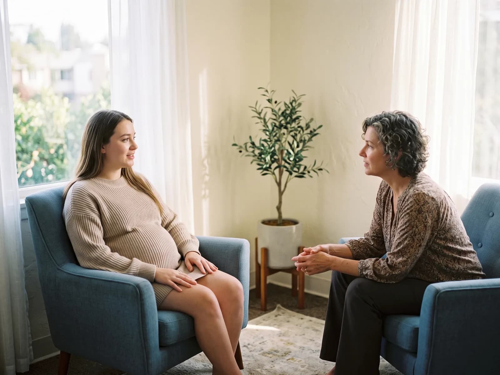 An expectant mother talking with a counselor at the first step of the adoption process
