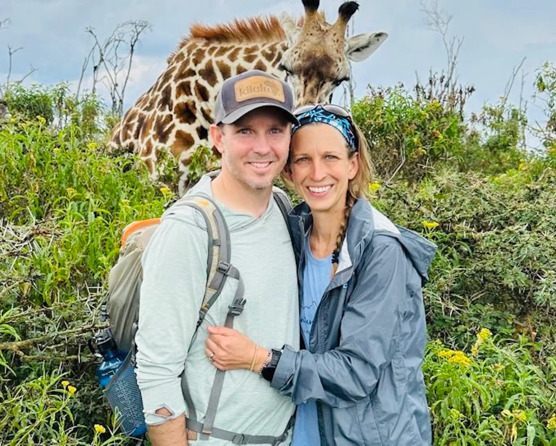 Eric and Anna on a hike in Kenya with a giraffe just behind them