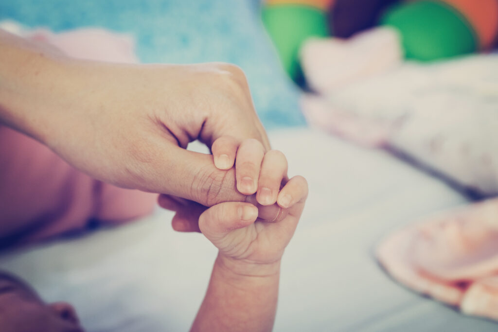 Close up hands of mother and baby